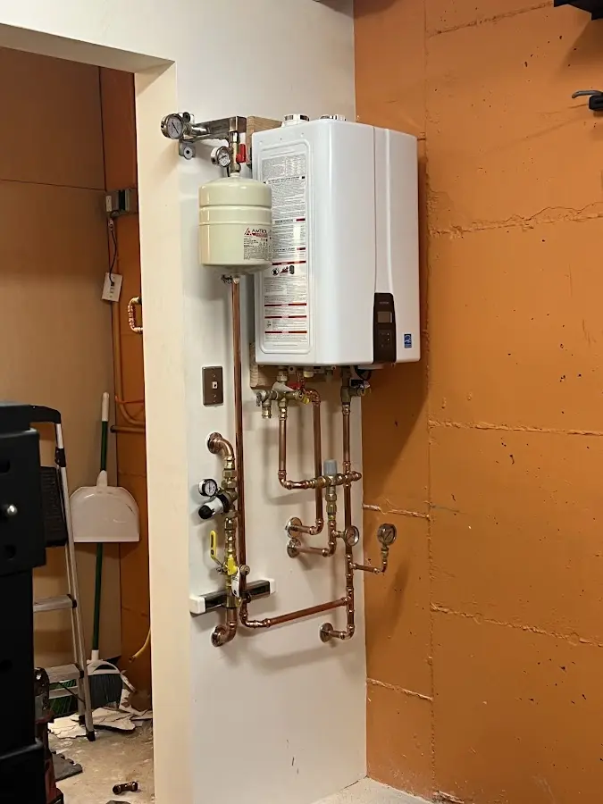 Plumbing technician inspecting water heater connections in Lake Forest Park